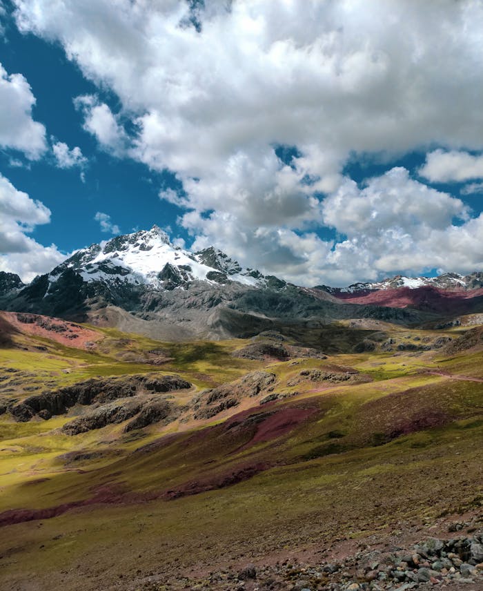 Beautiful panoramic view of the Andes mountains with vibrant slopes and a dramatic cloudy sky.